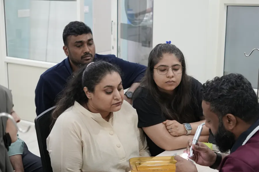 Participants practising technique at a table with course materials