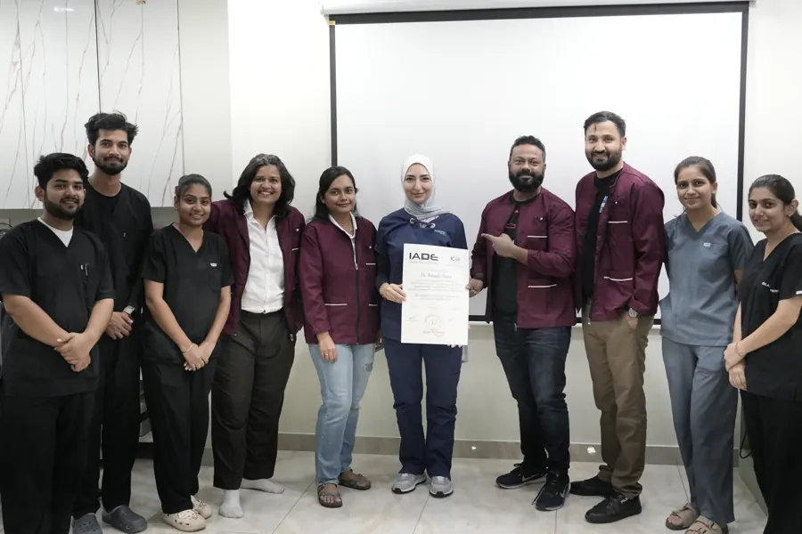Course participants and faculty standing together with a certificate